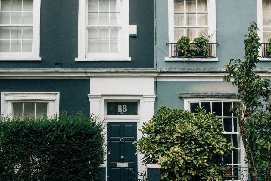 Rij groene woningen met struiken